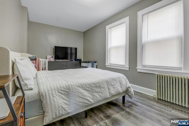 bedroom featuring radiator and hardwood / wood-style floors