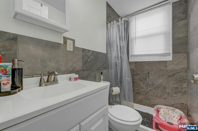 bathroom with vanity, curtained shower, tile walls, and toilet