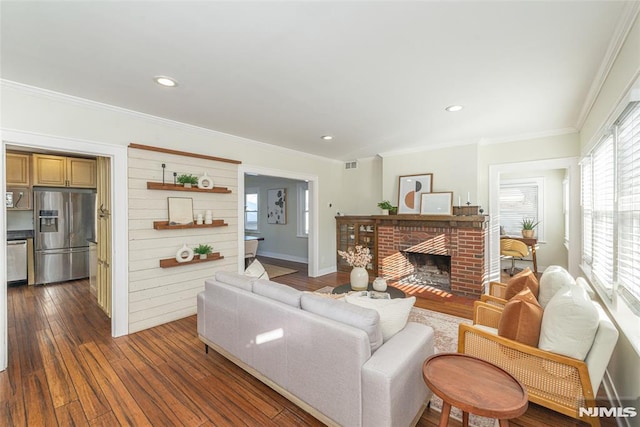 living room with a brick fireplace, crown molding, dark hardwood / wood-style flooring, and wood walls