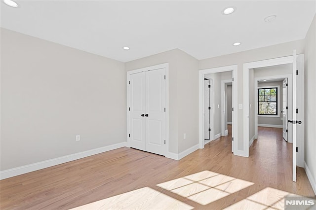 unfurnished bedroom featuring light hardwood / wood-style flooring and a closet