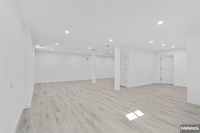 basement with light hardwood / wood-style flooring