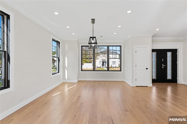 unfurnished living room with ornamental molding and light hardwood / wood-style floors