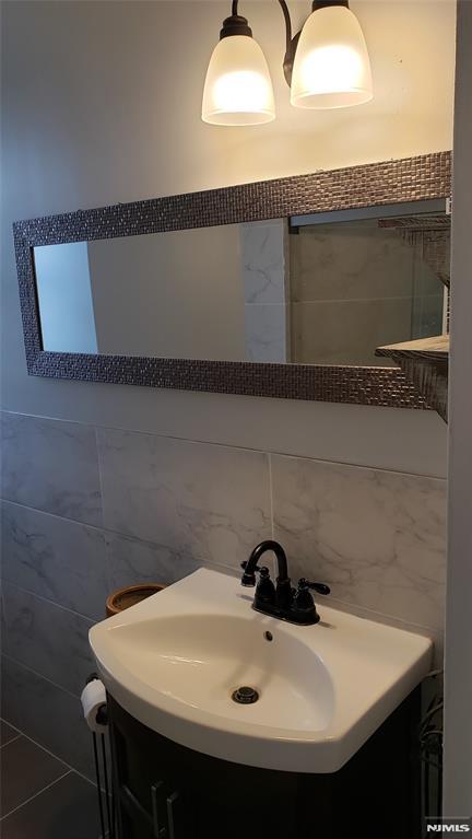 bathroom with vanity and tile walls