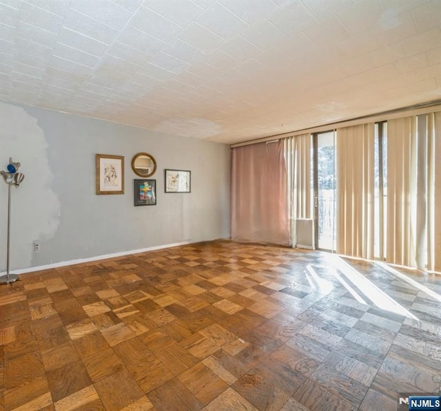 spare room featuring parquet floors and floor to ceiling windows