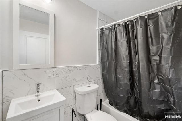 full bathroom with tile walls, toilet, vanity, and shower / bathtub combination with curtain