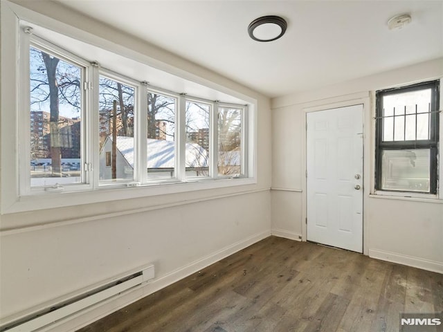 interior space featuring baseboard heating and dark hardwood / wood-style flooring