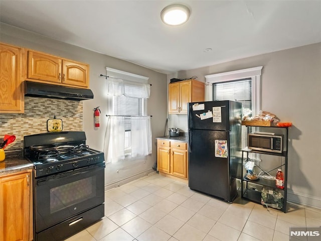 kitchen with light tile patterned floors, black appliances, tasteful backsplash, and a healthy amount of sunlight