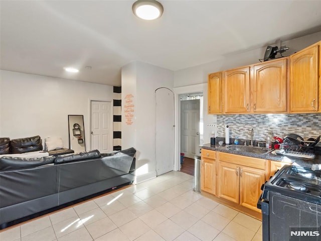 kitchen with black stove, sink, backsplash, and light tile patterned floors