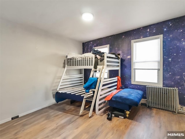 bedroom featuring wood-type flooring and radiator