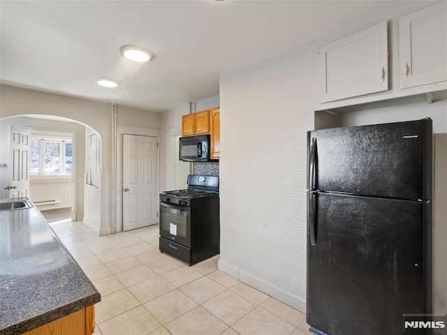 kitchen featuring light tile patterned floors, black appliances, and tasteful backsplash