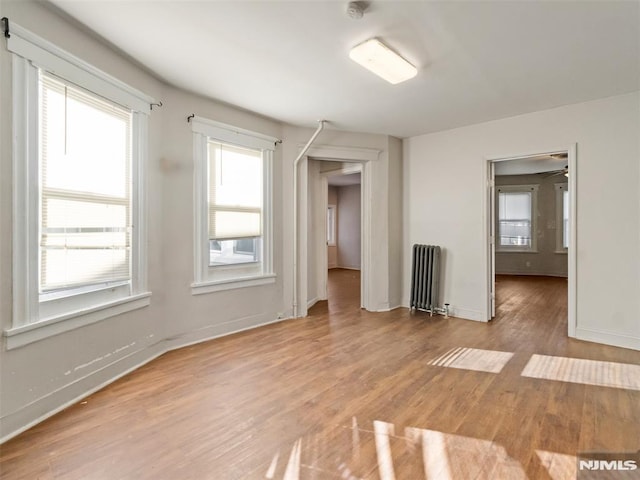 spare room featuring radiator and light wood-type flooring