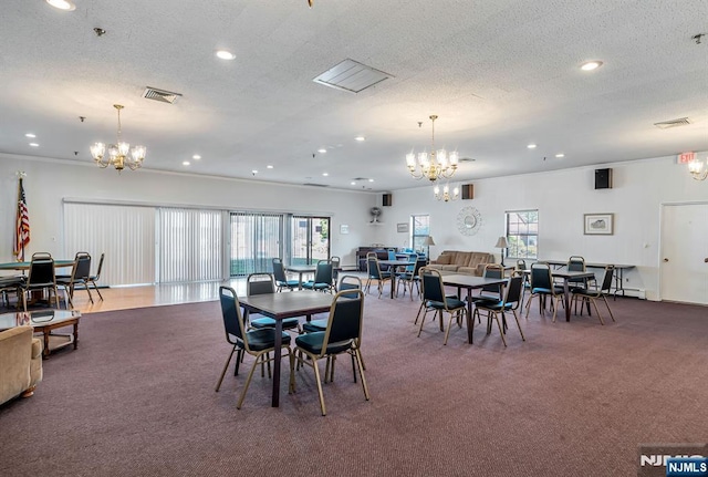 carpeted dining area featuring a wealth of natural light, a textured ceiling, and a notable chandelier