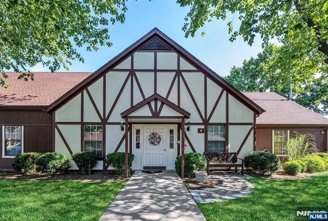 english style home featuring a front yard
