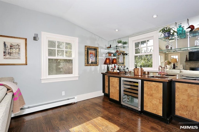 bar featuring a baseboard radiator, beverage cooler, a sink, lofted ceiling, and dark wood finished floors