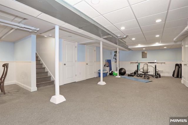 workout area featuring a paneled ceiling, wainscoting, and recessed lighting