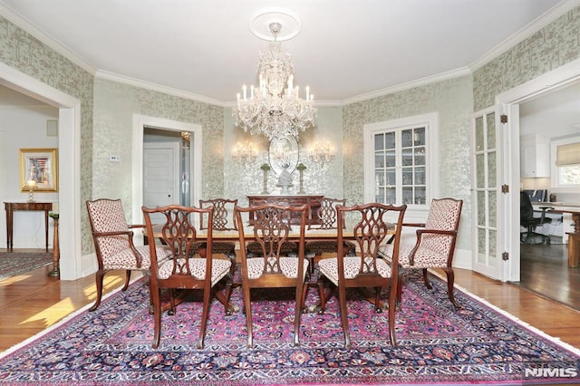 dining space with wallpapered walls, a notable chandelier, wood finished floors, and crown molding