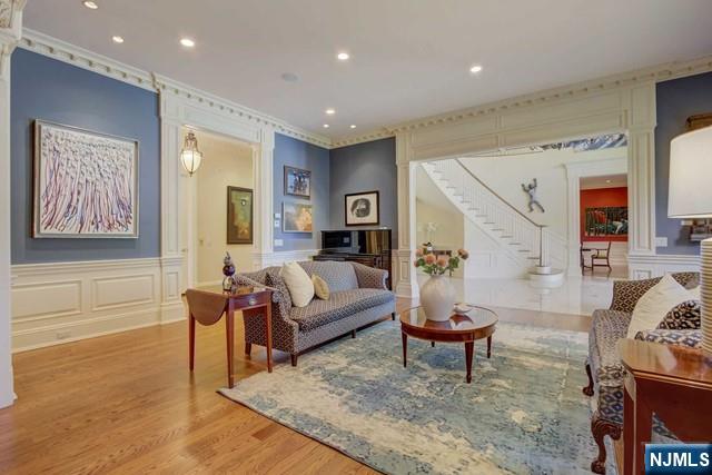 living room with crown molding, hardwood / wood-style flooring, and ornate columns