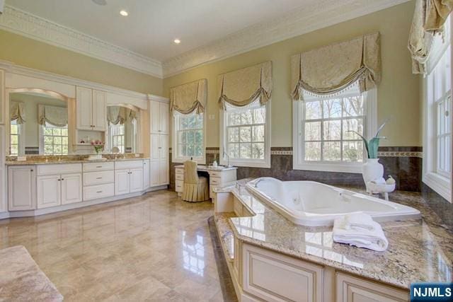 bathroom featuring tiled tub, vanity, and crown molding