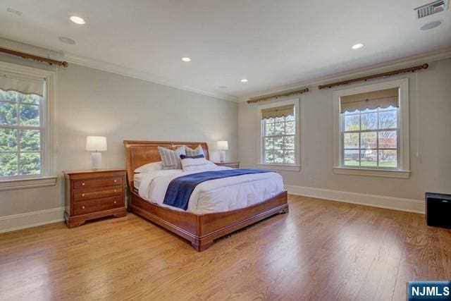 bedroom featuring ornamental molding and multiple windows