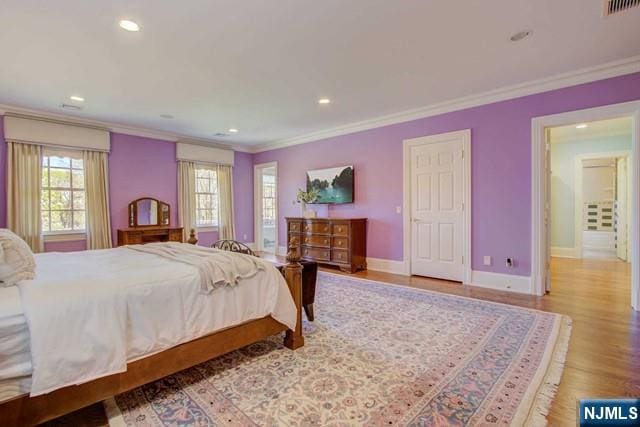 bedroom featuring ornamental molding and light wood-type flooring