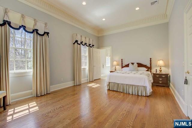 bedroom with hardwood / wood-style flooring and crown molding