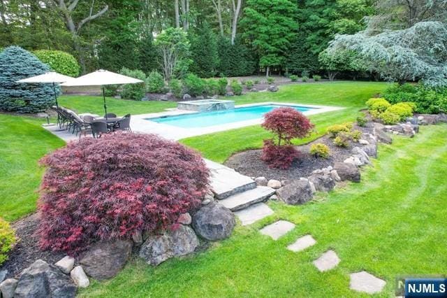 view of swimming pool with a yard, a hot tub, and a patio