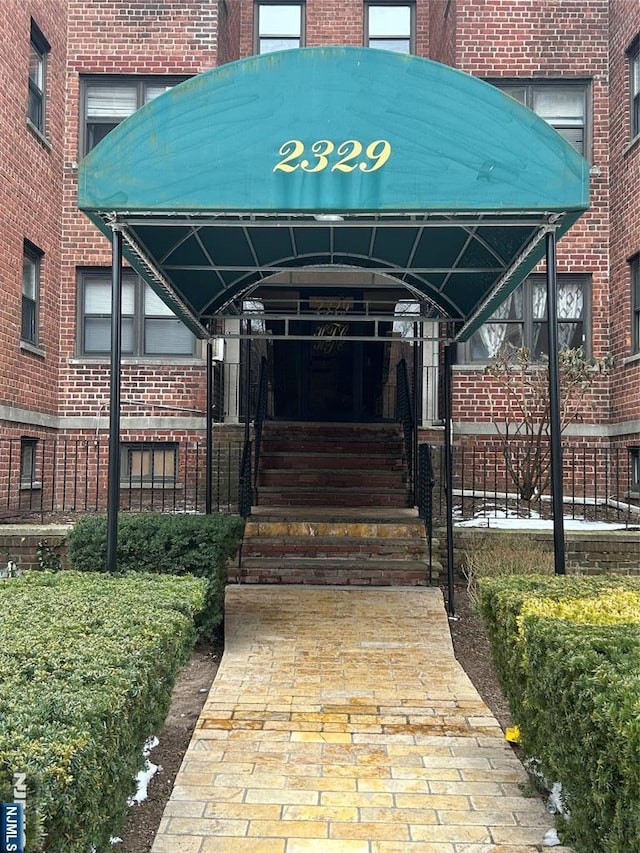 doorway to property featuring brick siding