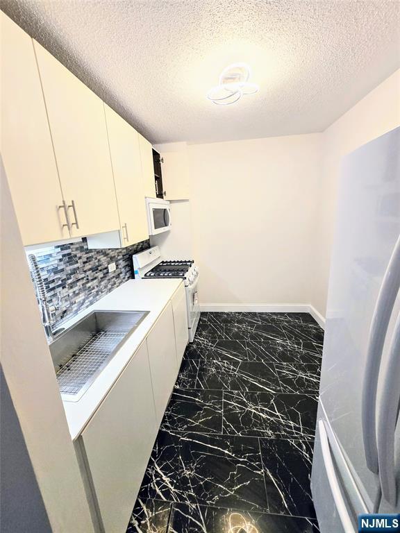 laundry area with a textured ceiling