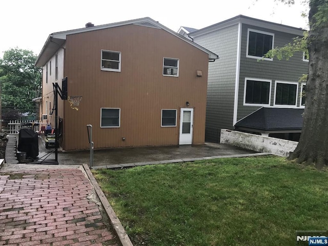 rear view of property featuring a yard and a patio area