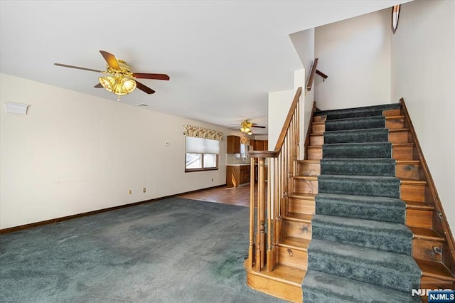 stairway with carpet floors, ceiling fan, and baseboards