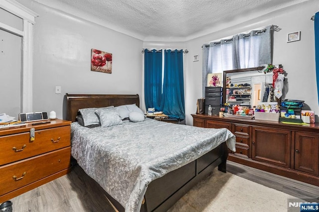 bedroom featuring hardwood / wood-style floors and a textured ceiling