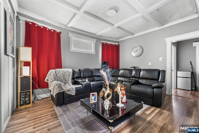 living room featuring beamed ceiling, coffered ceiling, hardwood / wood-style floors, and a textured ceiling