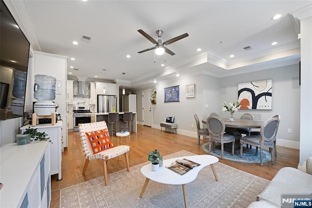 living room featuring crown molding, light hardwood / wood-style flooring, and ceiling fan