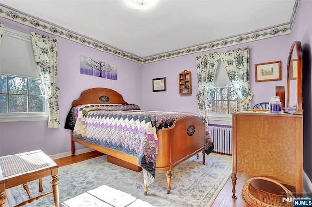 bedroom featuring radiator and light hardwood / wood-style flooring