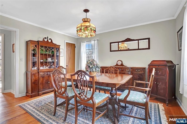 dining area with crown molding and wood-type flooring