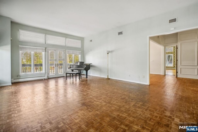 interior space featuring baseboard heating, dark parquet flooring, french doors, and a high ceiling