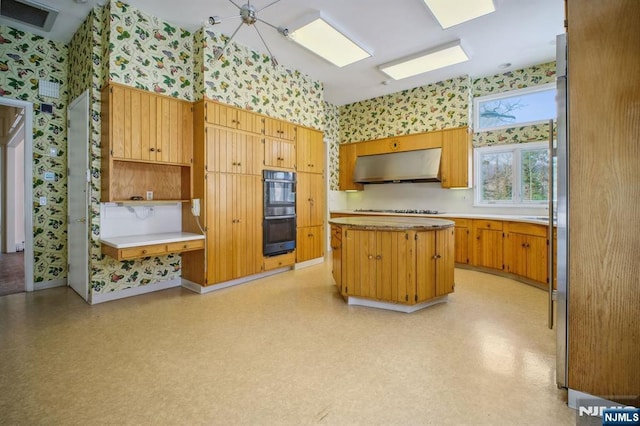 kitchen with gas cooktop, double oven, and a kitchen island