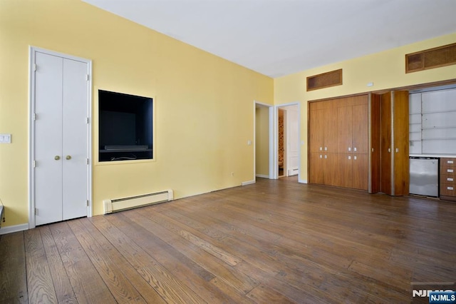 unfurnished bedroom with multiple closets, wood-type flooring, and a baseboard heating unit