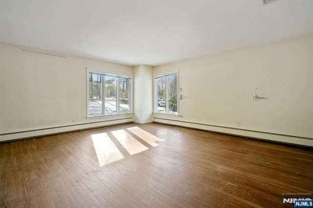 unfurnished room featuring hardwood / wood-style floors and baseboard heating