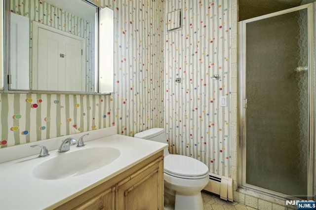 bathroom with a shower with door, vanity, baseboard heating, and toilet