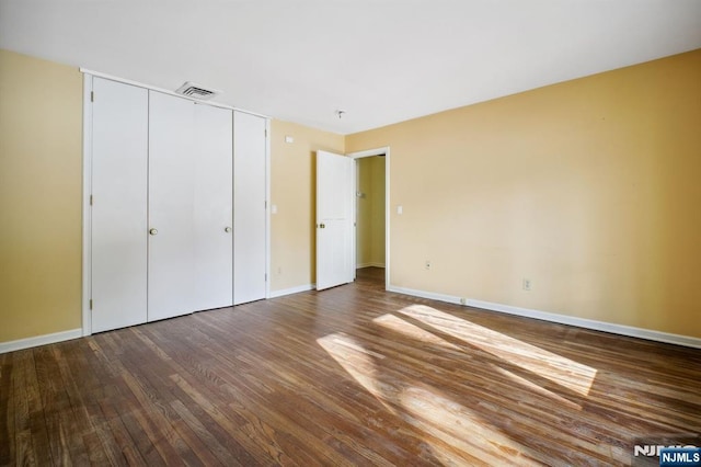 unfurnished bedroom with wood-type flooring and a closet