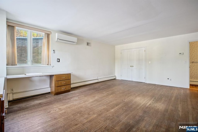 interior space with hardwood / wood-style flooring, a baseboard radiator, and a wall mounted air conditioner