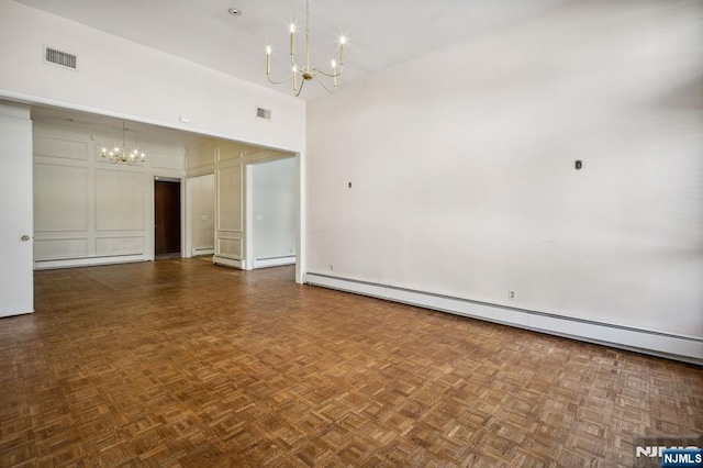 unfurnished room featuring dark parquet floors, an inviting chandelier, and baseboard heating