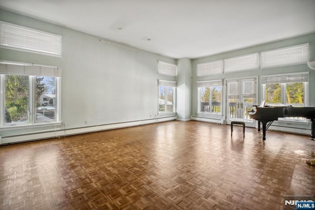 unfurnished living room featuring baseboard heating, parquet floors, and a high ceiling