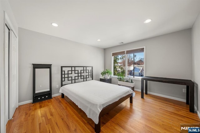 bedroom with light hardwood / wood-style floors and a closet