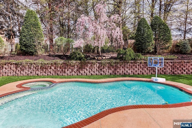 view of swimming pool with an in ground hot tub