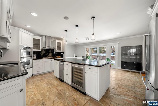 kitchen featuring pendant lighting, wall chimney range hood, white cabinetry, and beverage cooler