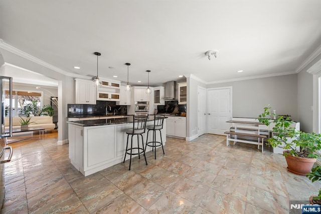 kitchen featuring double oven, white cabinetry, decorative backsplash, hanging light fixtures, and a center island