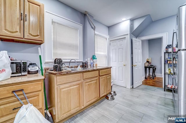 kitchen with sink, stainless steel fridge, and light brown cabinets