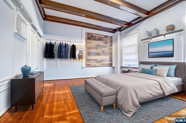 bedroom featuring dark hardwood / wood-style floors and beam ceiling